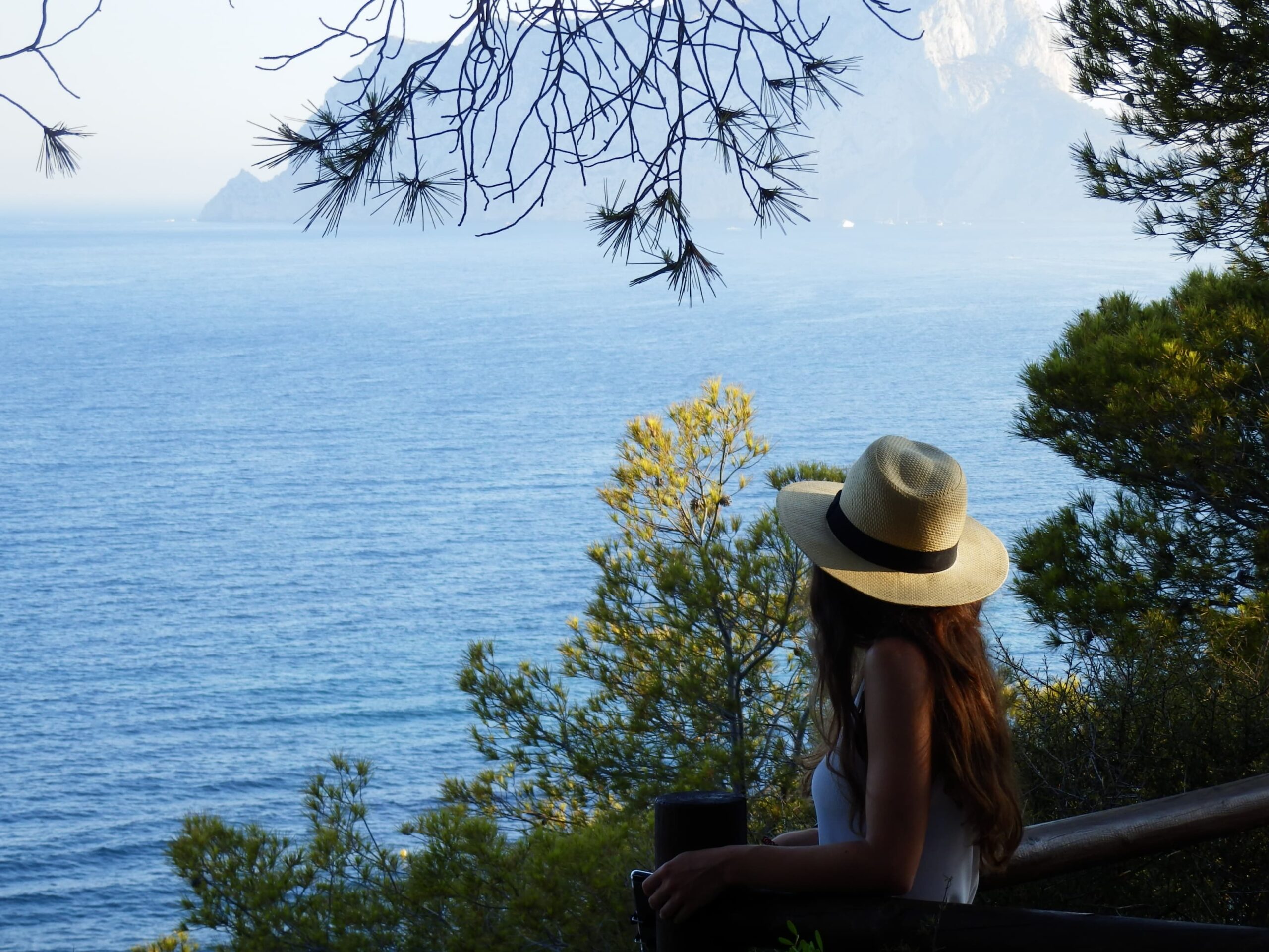 vrouw met hoed bij een meer